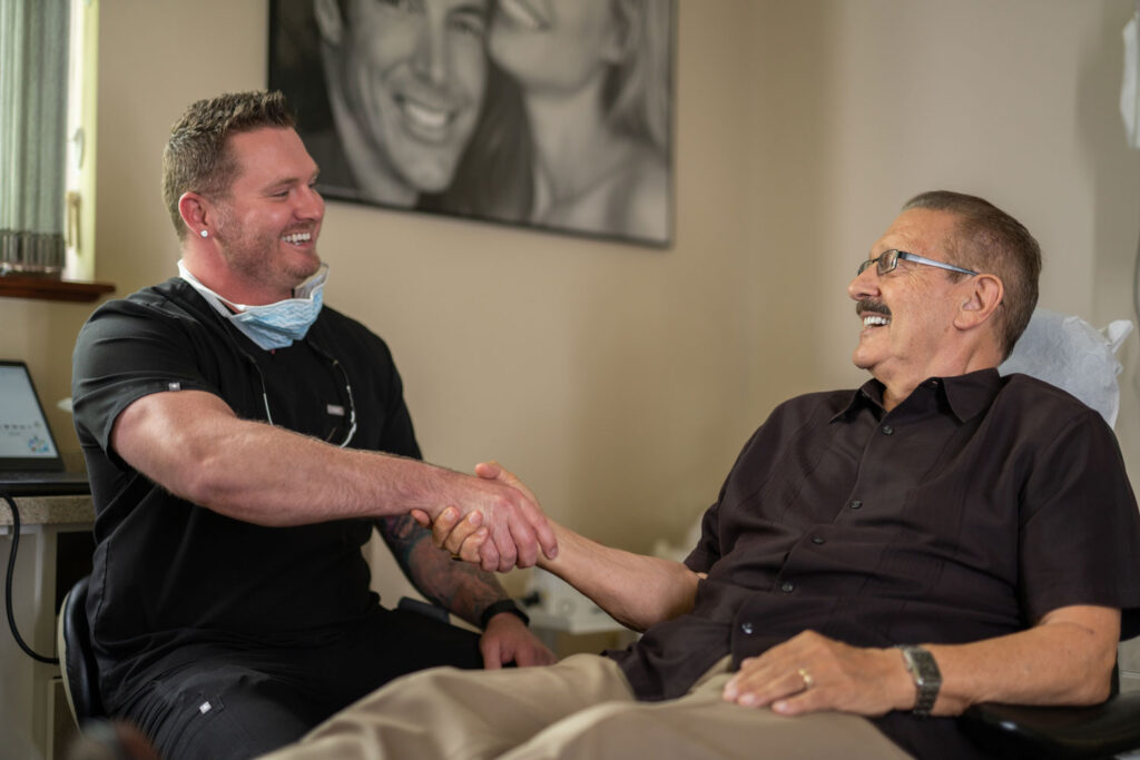 A dentist at Expressions Dental consulting with a patient about partial and full denture options, highlighting cost-effective tooth replacement solutions for improved oral health.